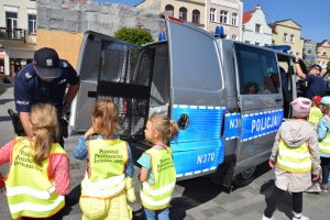 radiowóz, dzieci i policjant na rynku w Pucku