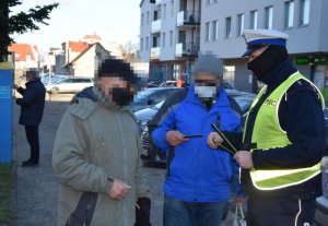 Policjant rozdaje odblaski przechodnią