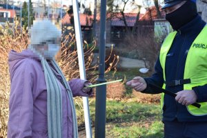 Policjant rozdaje odblaski przechodnią