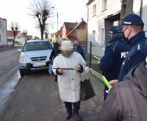 Policjant rozdaje odblaski przechodnią