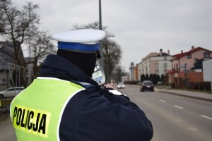 Policjant ruchu drogowego wykonujący pomiar prędkości.